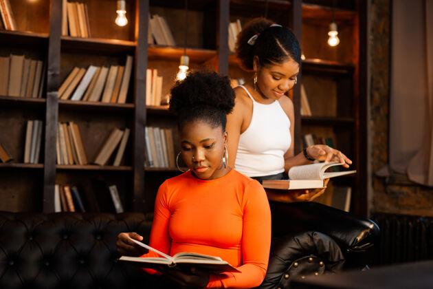 大学两个年轻的非洲女人在图书馆看书人图书馆民族