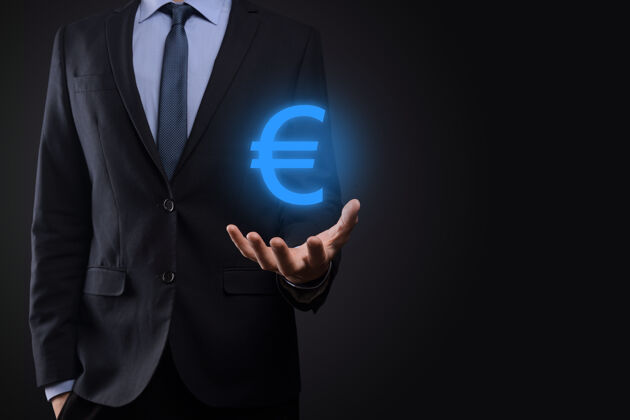 成功商人持有暗色背景上的欧元或欧元的货币图标不断增长的商业投资和金融货币概念财富闪亮物品