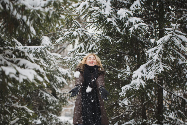 人美丽的女人在冬天的森林里摆姿势成人快乐女人