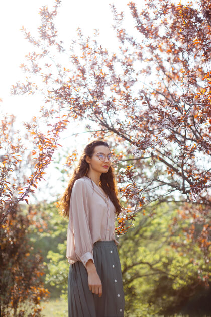 创意在樱花盛开的季节 美丽的年轻女子在公园里享受阳光明媚的春天模特花户外