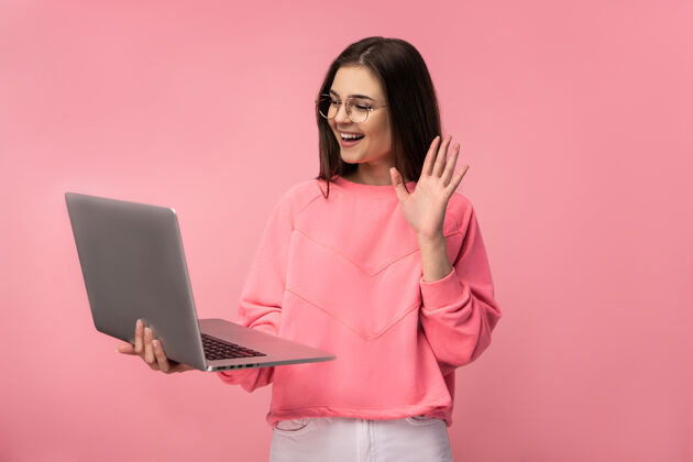 乐趣戴眼镜的美女在网上开会 手持笔记本电脑上网工作的照片心情女性自由式