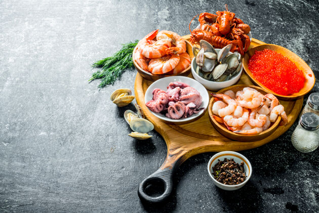 蟹海鲜.虾 小龙虾 牡蛎 章鱼和鱼子酱放在砧板上的碗里美食晚餐甲壳类动物