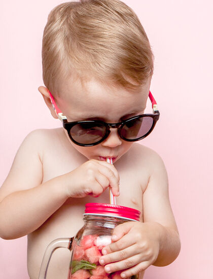 排毒小男孩喝着新鲜的柠檬水 加上一块西瓜和粉红色的冰块童年抗氧化剂自制