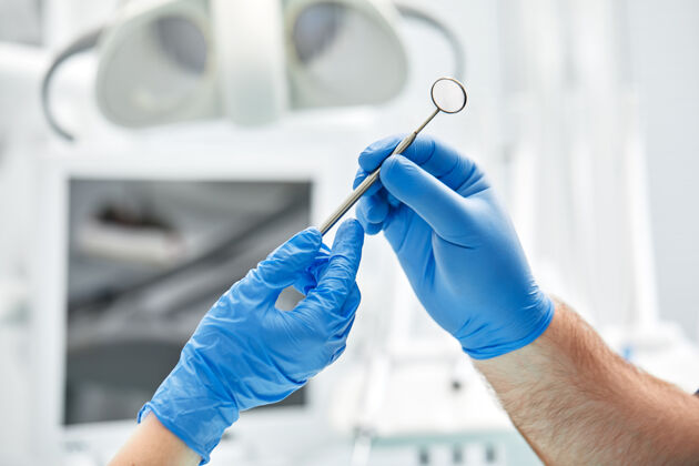 工作牙科植入手术期间 手术室上方牙医和护士外科医生的手的特写镜头牙科卫生人