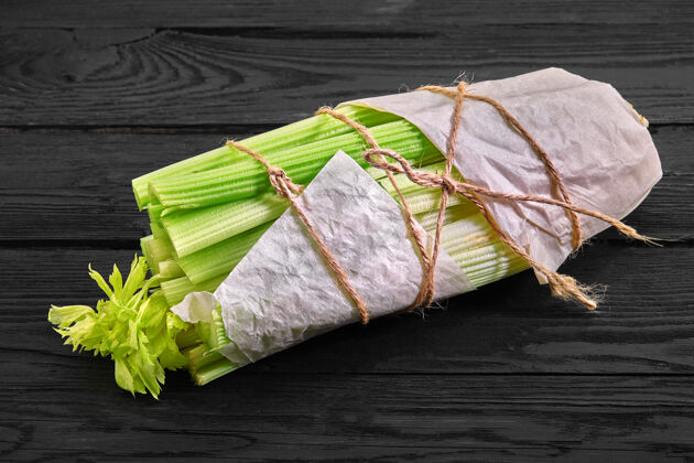 自然新鲜有机食品在手工纸袋新鲜蔬菜沙拉黄瓜芹菜洋葱鳄梨和欧芹在木制背景上复制空间木材蔬菜芹菜
