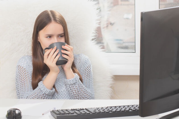 坐姿年轻女子在办公室工作时在电脑前喝咖啡税务专业打字