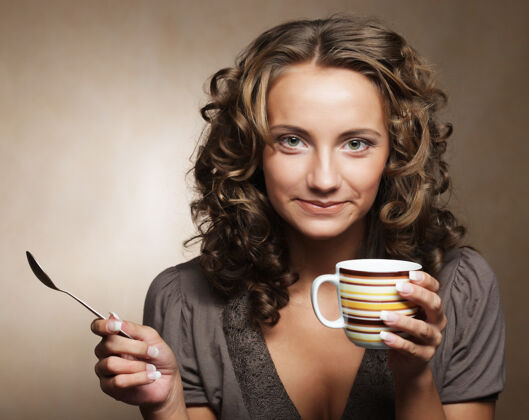放松年轻漂亮的女人在喝咖啡美女咬可爱