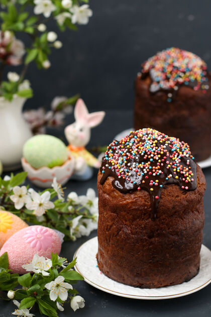 霜冻静物画复活节蛋糕覆盖着巧克力糖衣和彩色鸡蛋在黑暗的表面水仙花糕点甜点