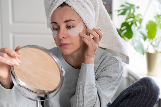 毛巾妇女用毛巾在头上涂水凝胶下眼睛恢复补丁在家里 看看镜子凝胶房子面膜