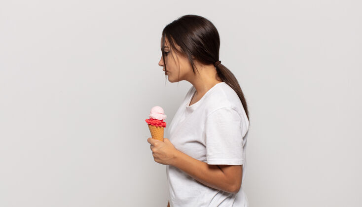 草莓冰淇淋年轻的拉美裔女性在侧视图中寻找复制空间 思考 想象或白日梦味道冰淇淋创意