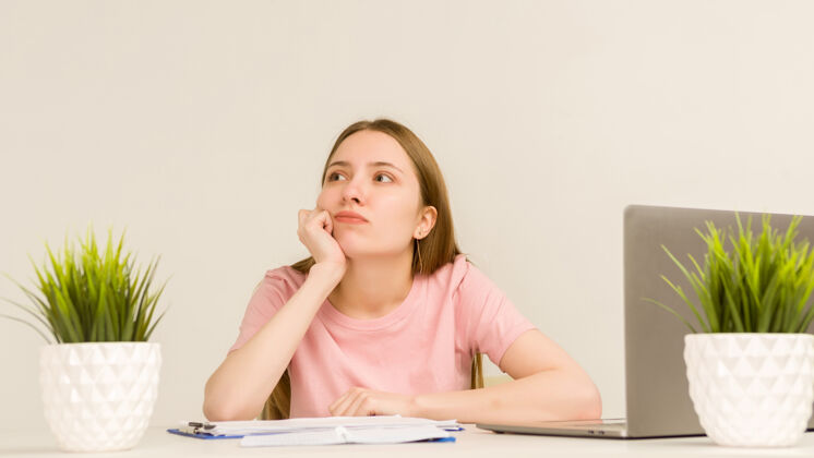 女性疲惫过度工作的年轻女实习生在办公室里用笔记本电脑工作-图片醒来在线疾病