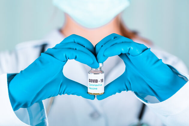 手套女医生或护士穿着制服 戴着手套 戴着口罩 在实验室里拿着一种形式的心脏药瓶 疫苗瓶上贴着冠状病毒-19疫苗标签预防诊所冠状病毒