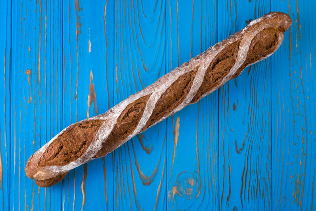 面包房蓝色木桌上法国法式面包的俯视图乡村面包长