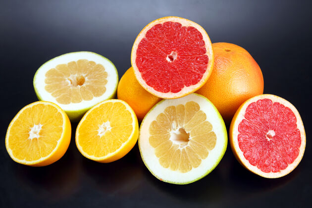 组在深色的背景上切块不同的柑橘类水果片切的食物