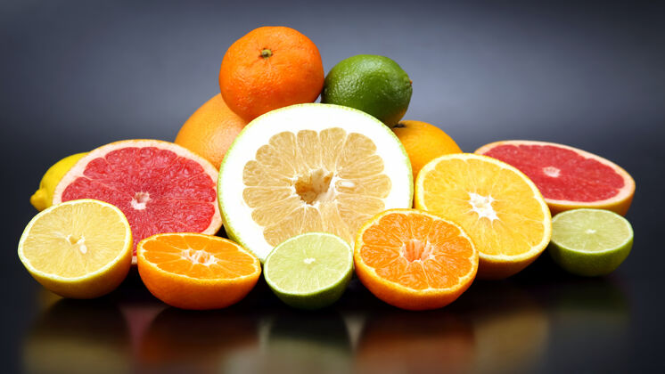 甜味在深色的背景上切块不同的柑橘类水果橘子甜点块