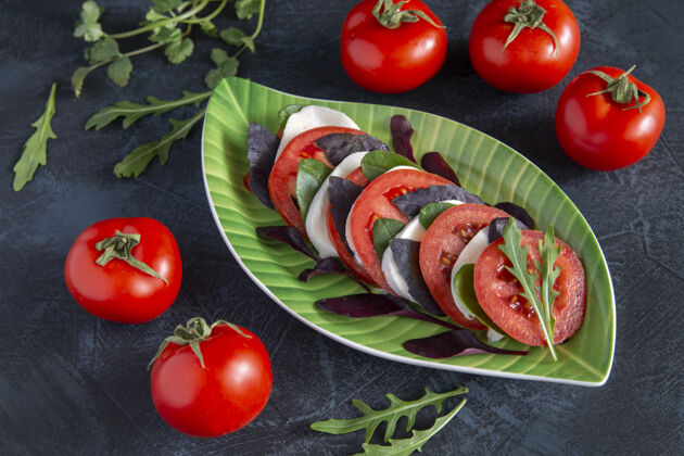 健康食品卡普雷斯沙拉的西红柿 马苏里拉和罗勒 芳香的草药和西红柿的背景上的表卡普雷斯沙拉卡普雷斯菜肴