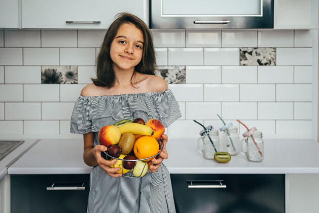 自然快乐的年轻家庭主妇 在现代化的厨房里享用水果房子新鲜女性
