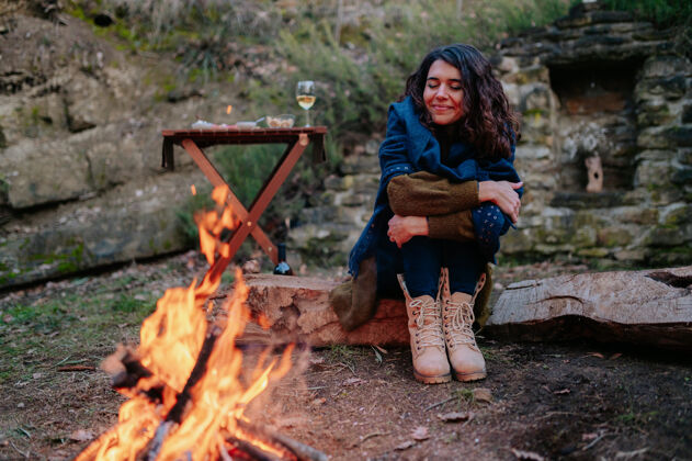 交谈冬日野餐时坐在火炉旁的年轻女子女人户外狗