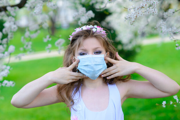 流行病春花里戴着医用口罩的少女花园.概念社会距离 预防冠状病毒青少年花园保健