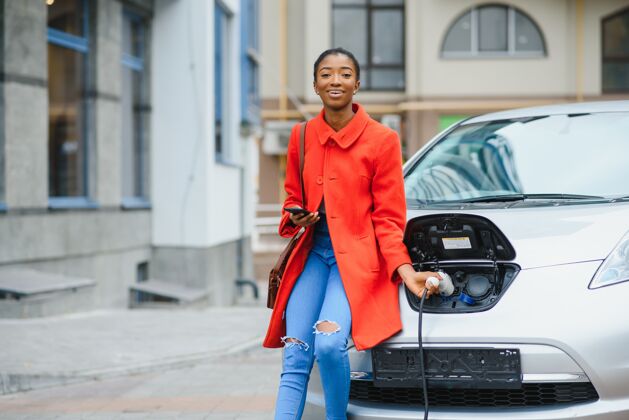 街道美国女孩在加油站给电动汽车充电清洁汽车信心