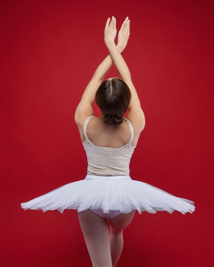 人迷人的芭蕾舞演员在红色背景上优雅地摆出姿势表演灵活芭蕾