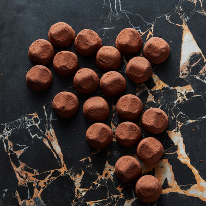 美食美味的巧克力松露在黑色大理石表面卷卡布奇诺饼干