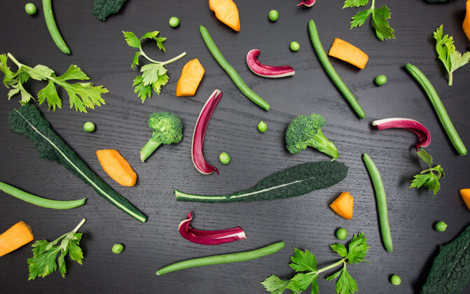 草药黑色桌子上各色蔬菜的俯视图健康植物新鲜