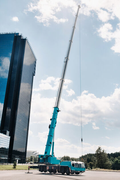 建筑最高和最大的蓝色汽车起重机被放置在一个平台上 旁边是一座大型现代化建筑机械工业起重机