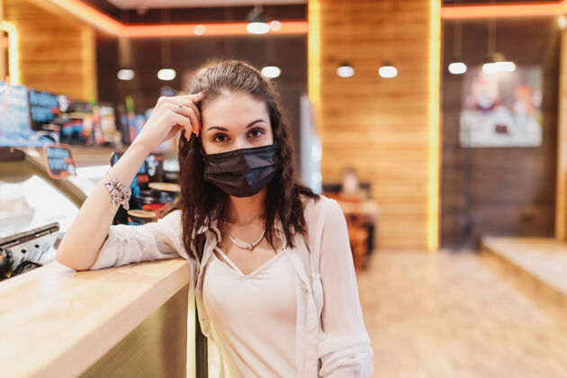 咖啡馆隔离率在一个咖啡馆 一个年轻女子在一个黑人面罩高高质量的照片医疗工作女商人