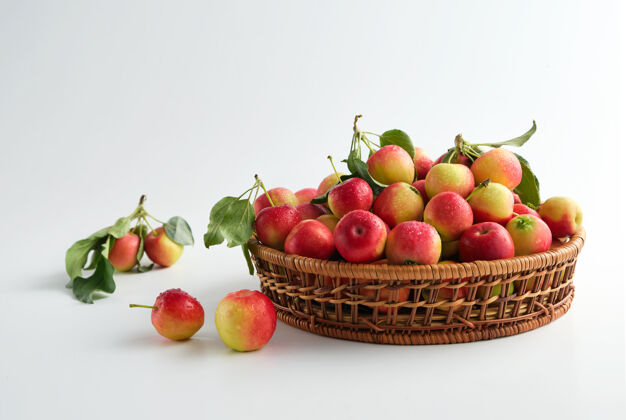 叶子红色和黄色的成熟苹果 叶子特写在柳条篮子里新鲜营养农作物