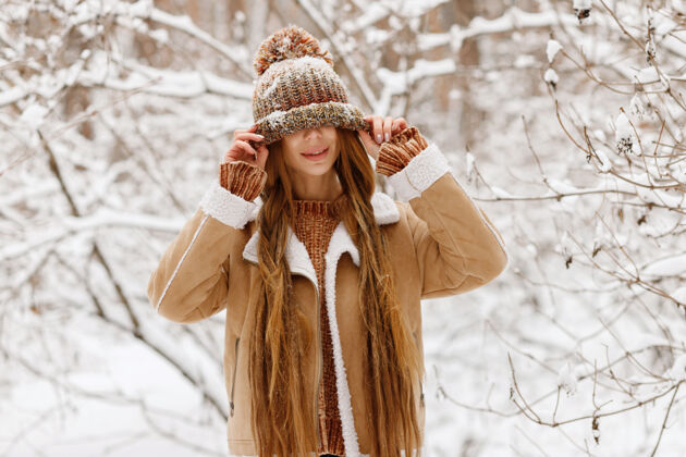 女人一个戴着帽子的女孩在冬天快乐地散步穿着城市女人