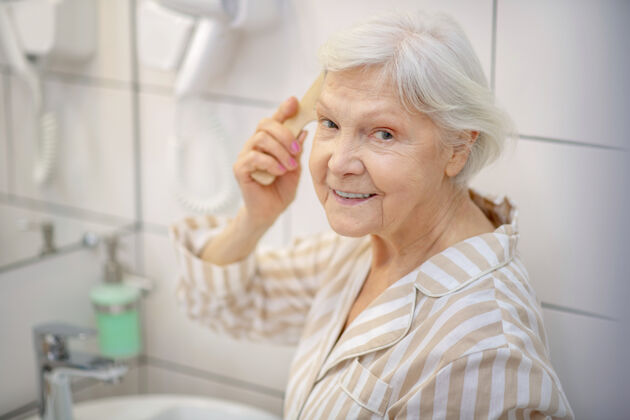 老太太很好心情灰色-有头发的女人在浴室里梳头 感觉很好健康发刷头发花白