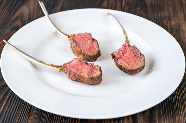 烹饪白色盘子上的羊肉架：顶视图饮食顶部腰肉