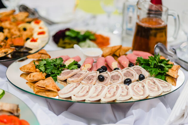 酱汁在餐厅里用香草和橄榄把新鲜的肉放在盘子里开胃晚餐装饰鱼片