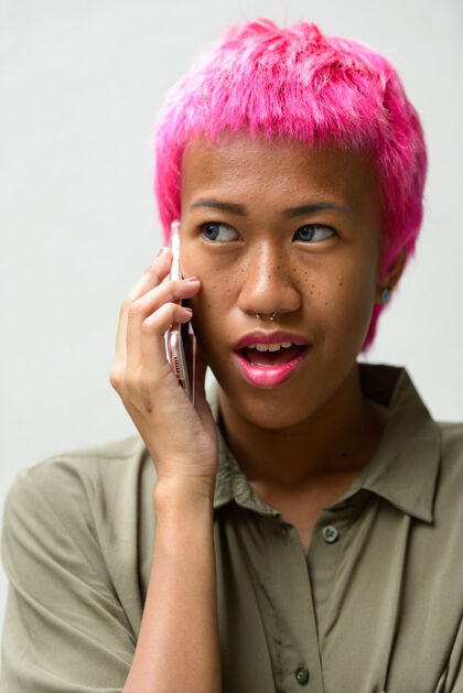 时尚年轻叛逆的亚洲女人的肖像 粉色的头发映衬着白色的空间泰语交谈朋克