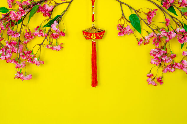 花吊坠为中国新年装饰（字的意思是财富）与中国花卉黄色背景吊坠结流苏