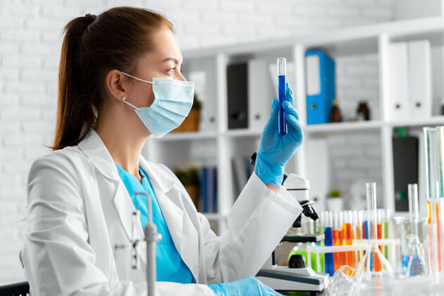 人女科学家或实验室工作人员拿着装有化学液体的玻璃瓶分析化学制服