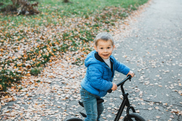 速度可爱的小男孩在户外骑自行车时微笑着儿子自行车孩子