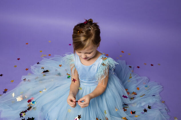 宝贝穿公主装的小女孩在玩紫色的五彩纸屑公主连衣裙有趣化妆舞会
