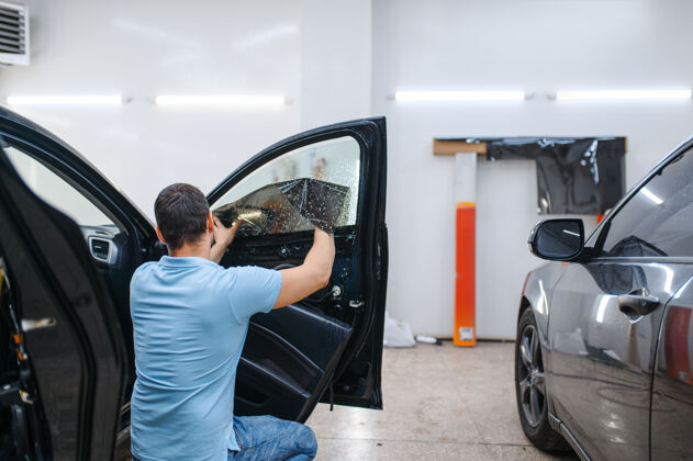 箔男性专业安装湿车染色 调音维修机械师在车库的车窗上涂乙烯基颜料机械工作汽车