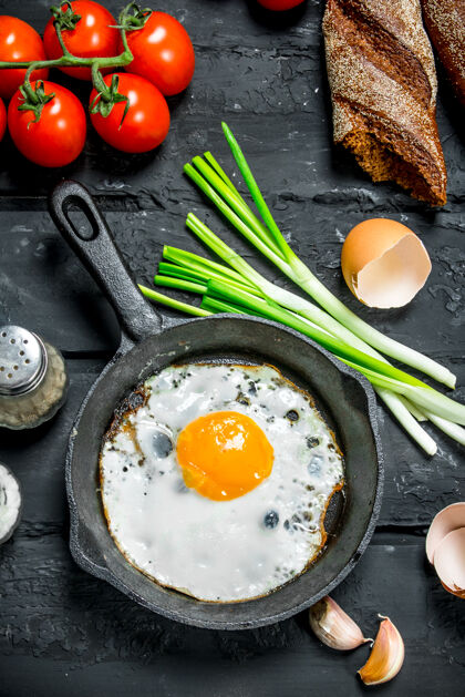 食物在平底锅里煎鸡蛋 配上面包和西红柿蛋黄背景热