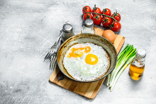 食物在平底锅里煎鸡蛋 加西红柿和葱热鸡蛋背景