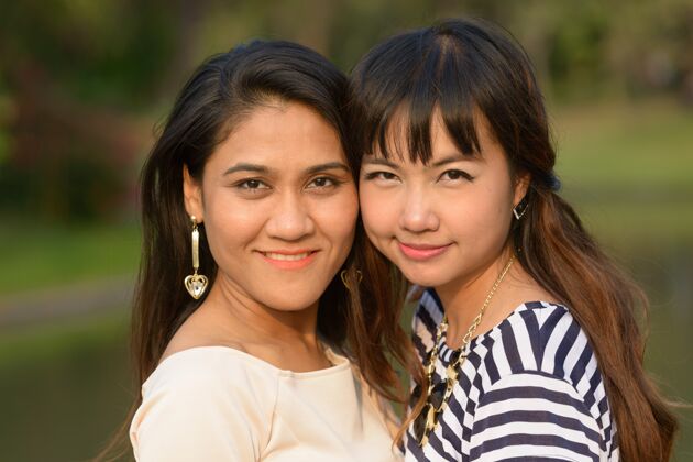 自然两位亚洲年轻女性在公园户外放松的写真放松公园爱情