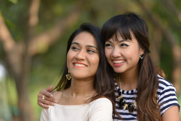 一起两位亚洲年轻女性在公园户外放松的写真公园东南浪漫