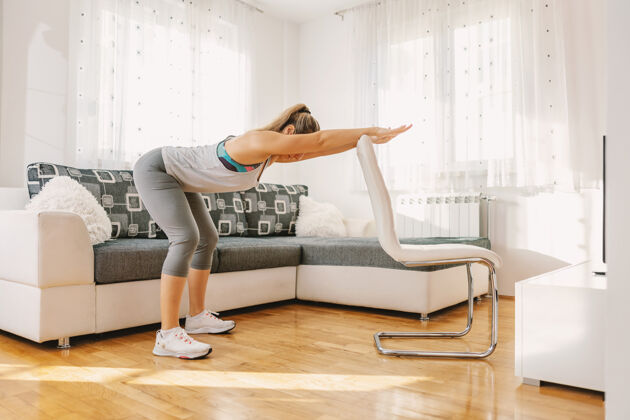 女性体格健壮的女运动员靠在椅子上做背部健身操运动员训练好动