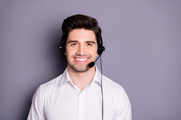 服务台自信酷的正面形象呼叫中心工作人员可以帮助解决问题戴黑色耳机穿正装衣服隔着灰色的墙工人领子耳机