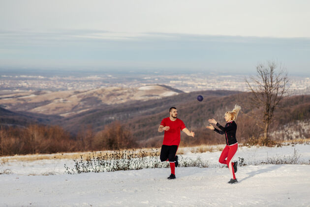 运动一对运动型情侣在冬季的艳阳天在大自然中跑步 锻炼身体球冬天健身 健康习惯 人际关系运动跑步运动