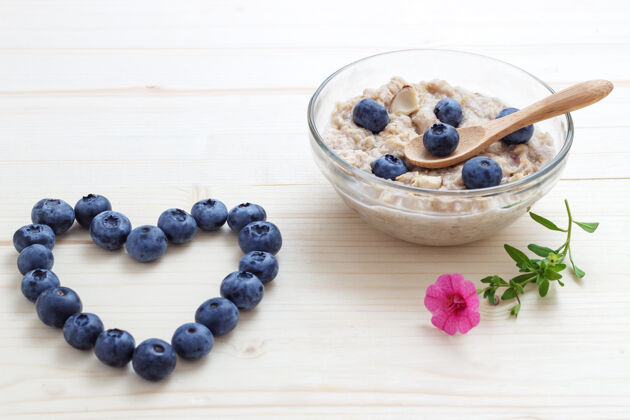 零食蓝莓和燕麦片与蓝莓和鲜花的心脏盘子粥健康