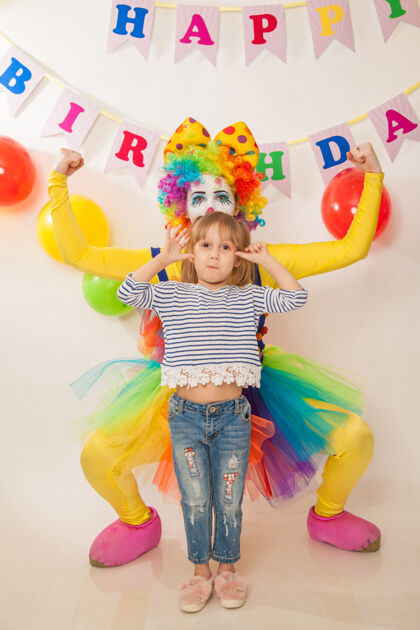 小丑女孩快乐的小丑女孩在节日里与生日女孩展示情感童年乐趣马戏团
