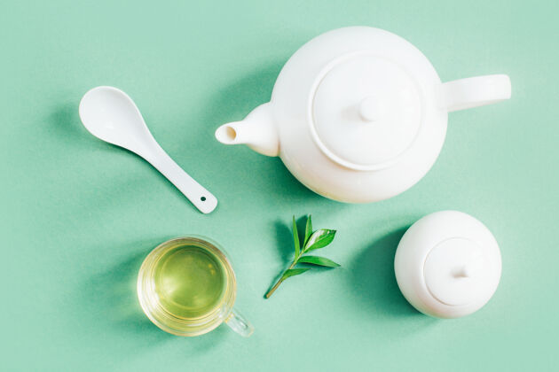 餐具一套茶具的俯视图茶壶糖碗杯茶上的绿色表面白茶壶白盘子杯子